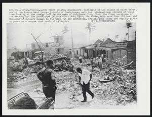 Residents of the island of Basse Terre, one of the French West Indies Islands of Guadeloupe, walk the rubble-strewn streets of their town looking at the damage left in the wake of Hurricane Cleo. Cleo, the first hurricane of the season, hit the Guadeloupe Islands 8/22. Now, 8/26, the storm, with more than 100 dead and millions of dollars damage in its wake in the Caribbean, crossed Cuba today and rapidly picked up power on a course that could hit Florida.