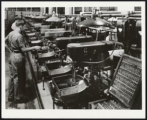 A production area of the American Optical lens plant in Southbridge, Mass. Curves are being generated in lens blanks, after which fine grinding and polishing of both sides produce a finished lens.