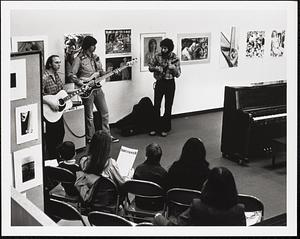 Guitar performance before an audience in the GCC art gallery