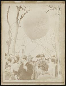 Youth carries balloon with message calling for the burning of local draft boards as crowd gathers in Central Park 4/15 to stage anti-Vietnam war demonstration.