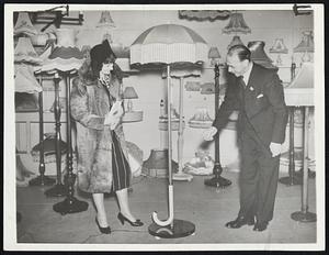 Chamberlain "Appeasement" Lamp. This "appeasement" lamp, fashioned after prime minister chamberlain's famous umbrella, made its appearance at the British Industries fair in London, Feb. 20 -- and created quite a stir. The woman at left is a buyer from Paris, - who placed a large order for the French market.
