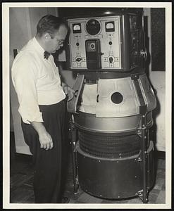 The Fade-Ometer being examined by a Physical Chemist of the Textile Clothing and Footwear Division is employed to accelerate color fading. A direct current arc is employed to simulate sunlight equal in intensity to summer sunlight in Florida. The Fade-Ometer determines the resistance of dyed fabrics to fading under use conditions.