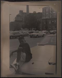 Boy posing on hood of car