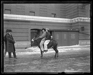 Two women riding a donkey