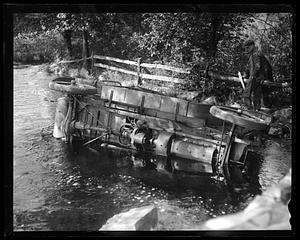A car on its side in a body of water