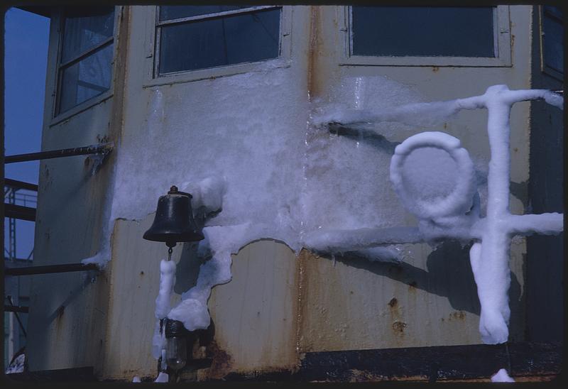 Bell on ship wall, surrounded by ice