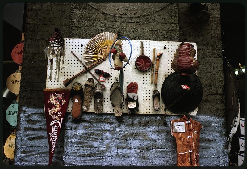 Items for sale on board with Souvenir of Chinatown pennant, New York City