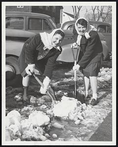 Slush Fun--A warm sun yesterday reduced curbstone snowpiles to slushy puddles, calling for new post-storm shoveling chores. Frances Butt, left, and Ruthie Acheson, both Belmont High students, do their stint in Belmont Center.