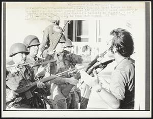 National Guard troops on the University of New Mexico campus here 5/8 confront a peace demonstrator moments before state police cleared a building of students. A total of 11 persons were injured, 10 from stab wounds.