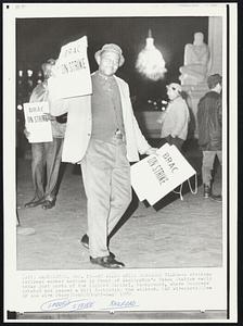 He Walks While Congress Talks -- A striking railroad worker marches in front of Washington's Union Station early today just north of lighted Capitol, background, where Congress debated and passed a bill forbidding the walkout.