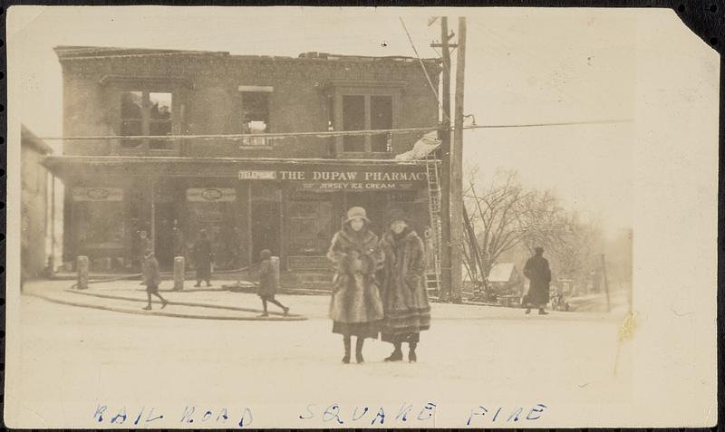 Lena Lillis and Cecil Tarbell in front of burned-out DuPaw Pharmacy, Railroad Square