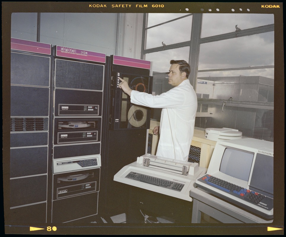 An image from 1978 shows a white man pressing buttons on an old, room-sized computer.