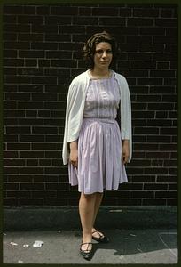 Girl standing in front of brick wall