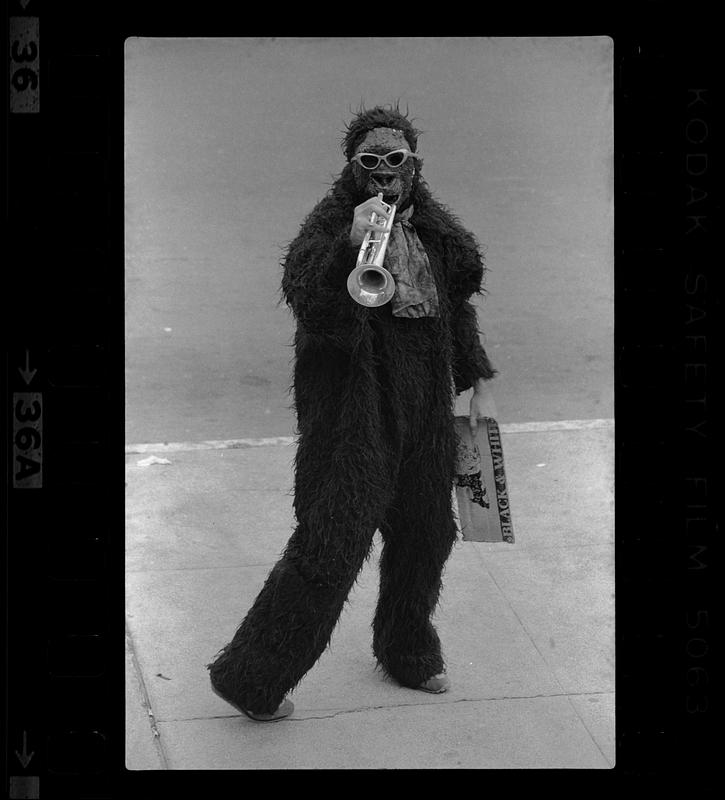 Person in ape costume with trumpet - Digital Commonwealth