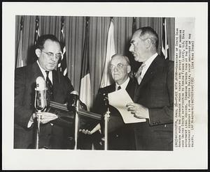 Peace with Japan--Secretary of State Dean Acheson puts the Japanese peace treaty into effect today by handing over United States ratification to Adrian Fisher (left), U.S. State department legal advisor. Standing between them at the state department ceremony is John Foster Dulles, chief architect of the treaty.