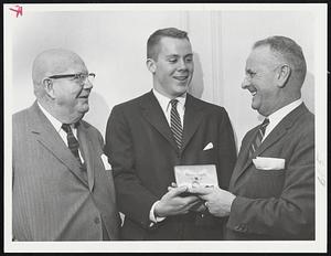 Blue’s Blue Ribbon winner, Quarterback Tom Singleton of Yale accepts 22nd Bulger Lowe Award for New England’s outstanding player, from John “Smoky” Kelliher at Gridiron Club Dinner. At left is Nils V. “Swede” Nelson, chairman of selection committee which chose top collegian.