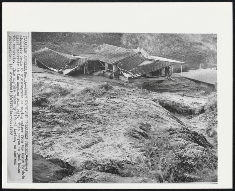 Burst Reservoir Unleashes Torrent--Houses alongside begin to disintegrate as raging waters from the burst Baldwin Hills Reservoir in Los Angeles surg past. This canyon is just below the reservoir. This picture was taken by Richard Levine, an amateur photographer.