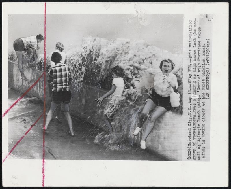 What Fun -- This unidentified group of vacationers, hets a ducking as high waves lash the seawall at Atlantic Beach today. 'Connie' with Hurricane force winds is moving closer to the North Carolina coast.