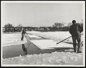 These men are pushing the ice around a curve in the canal.