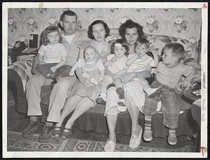 Share Home With Tornado Stricken Family-Mr. and Mrs. Charles Sjolander (left) holding Charles, Jr., four months, and Holly, 2 1/2, share their home at 57 Rowena St., Worcester, with Mrs. Joseph Rousseau and her family, twins Donna and Dennis, 17 months, and Richard, 4. Sjolander rescued twins from Rousseau home, 24 Housatonic St., when tornado struck.