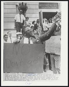 Draft Card Burning-- A follower of Cassius Clay burns what he called his draft card in front of the induction station in Houston, Tex., today after the heavyweight champion refused to be inducted into the Army. Pickets carrying signs paraded in front of the post office station where the center is located.