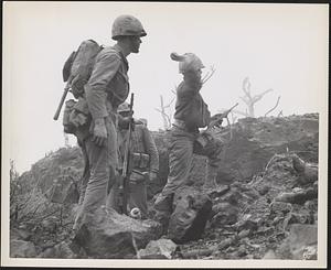 Marines, cornering a group of [Japanese] in a cave on the northern part of [Iwo Jima], "shell" the enemy with hand grenades