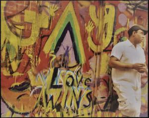 Man standing by graffiti wall