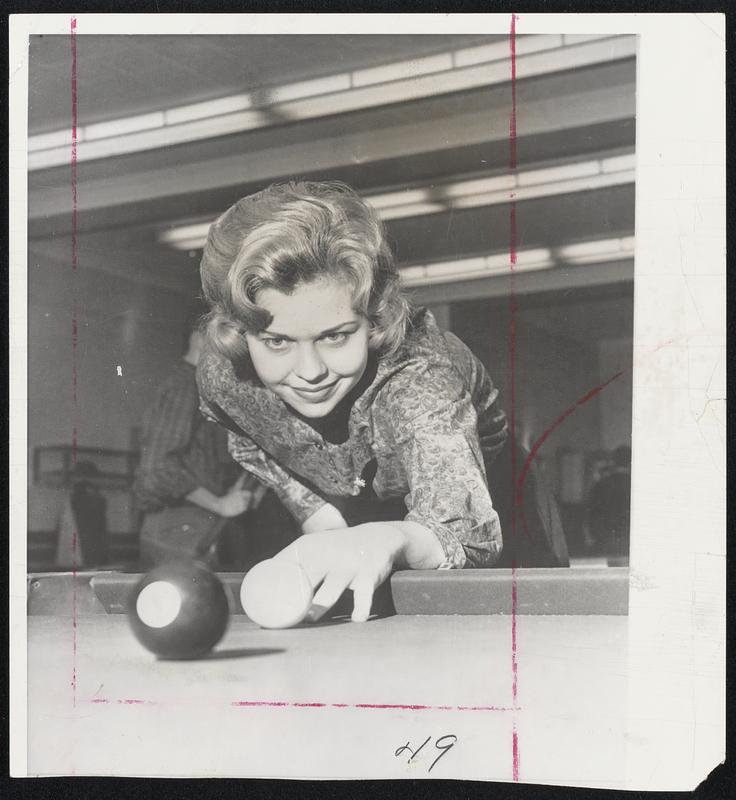 Co-Ed Billiard Star demonstrates how a champion accomplishes a difficult shot. Bland Anne Sidlauskas 19-year-old Indiana University sophomore, is defending titlist in the National Collegiate Co-ed Billiards Championship.