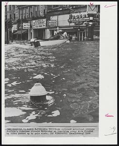 Virginia Venice-An outboard motorboat cruises Norfolk's downtown streets Wednesday as low-lying areas were flooded by tides pushed up by gale winds.