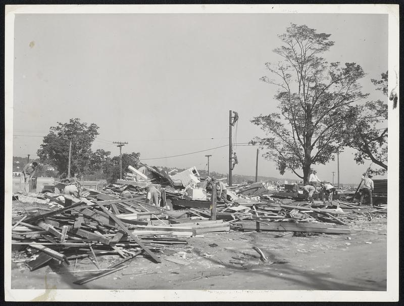 Tornado Debris is still tangled in many sections of storm-battered Worcester. Here workmen, including telephone and electric light linemen, continue the task of bringing order out of chaos.