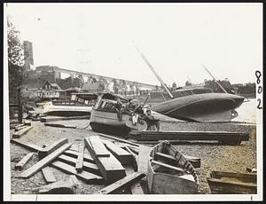 Big boats, little boats and assorted driftwood were piled together on this beach near the Fore river bridge, Weymouth, after the gale had roared northward.