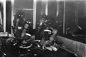 Chelsea firefighters Paul Sweeney and Dick Colette, far right, advance an attack line with Boston firefighters assisting