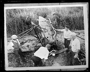 People examining a wrecked airplane
