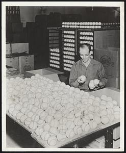 Final Check -- Major League baseballs are given final check by A. G. Spalding employee before stamped with American or National League markings. Balls used by two leagues are exactly the same. Balls in background have been stamped and are ready for shipment.