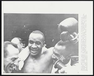Liston Raises Arm in Victory--Exuberant handlers crowd about as Sonny Liston, new world heavyweight champion, raises a gloved hand tonight--symbol of victory. Advisor Jack Nilon is at left. Liston kayoed Floyd Patterson in first round.