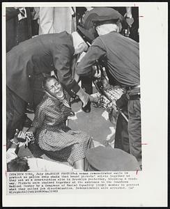 New York – Noisy Protest – A woman demonstrator wails in protest as police snip chain that bound pickets’ wrists together as they sat at a construction site in Brooklyn yesterday, blocking a roadway. Pickets were chained together at the entrance to the Downtown Medical Center by a Congress of Racial Equality (CORE) member to protest what they called job discrimination. Demonstrators were arrested.