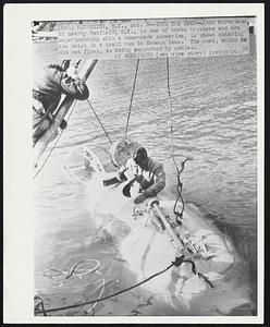 Into the Deep--John McFarlane of nearby Penfield, N.Y., is one of three brothers who are experimenting with a home-made submarine, is shown entering the hatch in a trail run in Seneca Lake. The boat, which did not float, is being supported by cables.