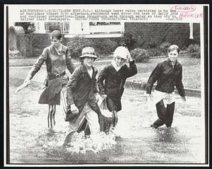 Although heavy rains persisted in the eye of hurricane Ginger 9/30 afternoon, residents went about the task of daily jobs and continued preparations. These youngsters wade through water as they try to deliver their newspapers.