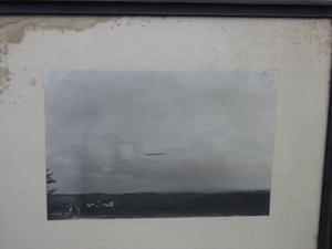 Framed photograph of a landscape with an airship