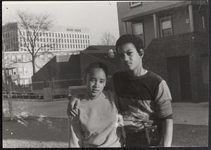 Young girl and boy standing outside