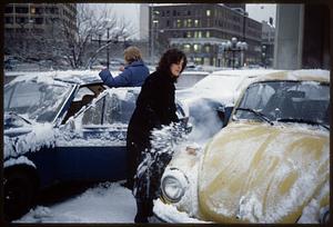 Scraping ice off cars in winter, Cambridge