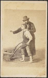 Man showing boy how to use a plow