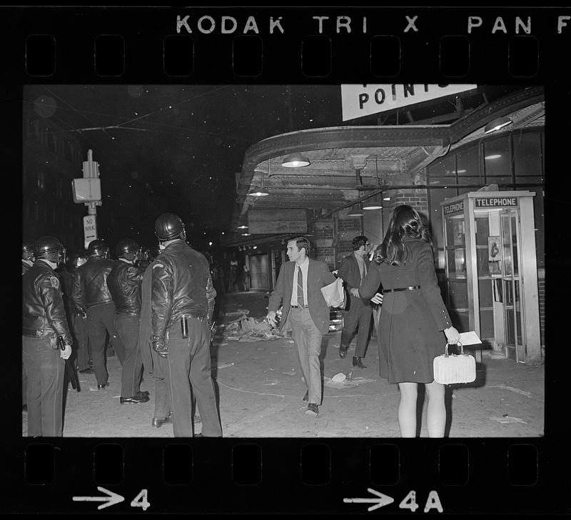 Harvard Square anti-war riot: Burning newspapers at subway kiosk, Cambridge