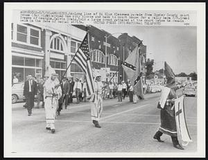 Long line of Ku Klux Klansmen parade from Sumter County court house (far right)around two city blocks and back to court house for a rally here 8/8.Grand Dragon of Georgia, Calvin Craig, told a large crowd gathered at the court house to remain calm in the face of racial strife.