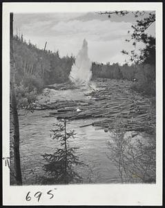 Pulp Mills Resume Production. Quebec, Canada -- Pulp and paper products, Canada's major industry, is returning to post war production and lumberjacks are sweeping rivers and streams in the drive to restore the country's export trade. Before the war, Canada produced newsprint that made up two-thirds of the world's export trade of this commodity. During the war the 108 mills operated by 82 companies were converted to the production of military goods made on a 24-hour day schedule. This year's pulp log drive is of record proportions. Since Spring, rivers and streams have teemed with activity as millions of logs were driven down to mills for processing. Here, log jams are broken with dynamite in the Desert River in the Gatineau District.