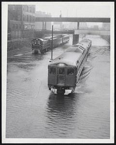 Slowly but Surely these trains push through the flooded areas of the New Haven Railroad tracks near Broadway, South End. Service was slowed to a standstill in some sections.