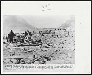 Looking For Victims Of Italian Flood -- Italian troops search through wrecked village of Longarone today for victims of flood waters from nearby Vaiont dam. Hundreds of persons died in the flood produced when a mountainous landslide crashed into the reservoir behind the dam.
