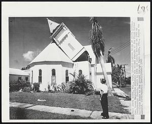 The Leaning Tower of Punta Gorda--Rev. Reese Henderson examines the tilted steeple of the First United Presbyterian Church, built in 1901 and nearly wrecked in 1960 by Hurricane Donna as she passed through Punta Gorda, Fla., during the weekend.