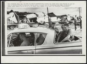 Open Air View of Destruction--A broken car window gives three Marines an open air view of destruction left by Hurricane Camille after it ripped into the Mississippi Gulf Coast at Gulfport, Sunday night. Winds of up to 150 m. p. h. caused heavy damage in the area.