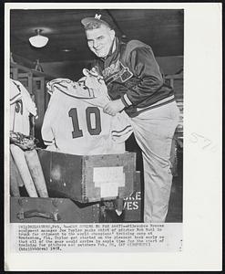 Can Spring be Far Away?-Milwaukee Braves equipment manager Joe Taylor packs shirt of pitcher Bob Buhl in trunk for shipment to the world champions' training camp at Bradenton, Fla. Taylor got started on the pleasant taks early so that all of the gear would arrive in ample time for the start of training for pitchers and catchers Feb. 20.